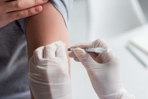 Przycięty widok lekarza wykonującego szczepienie pacjenta